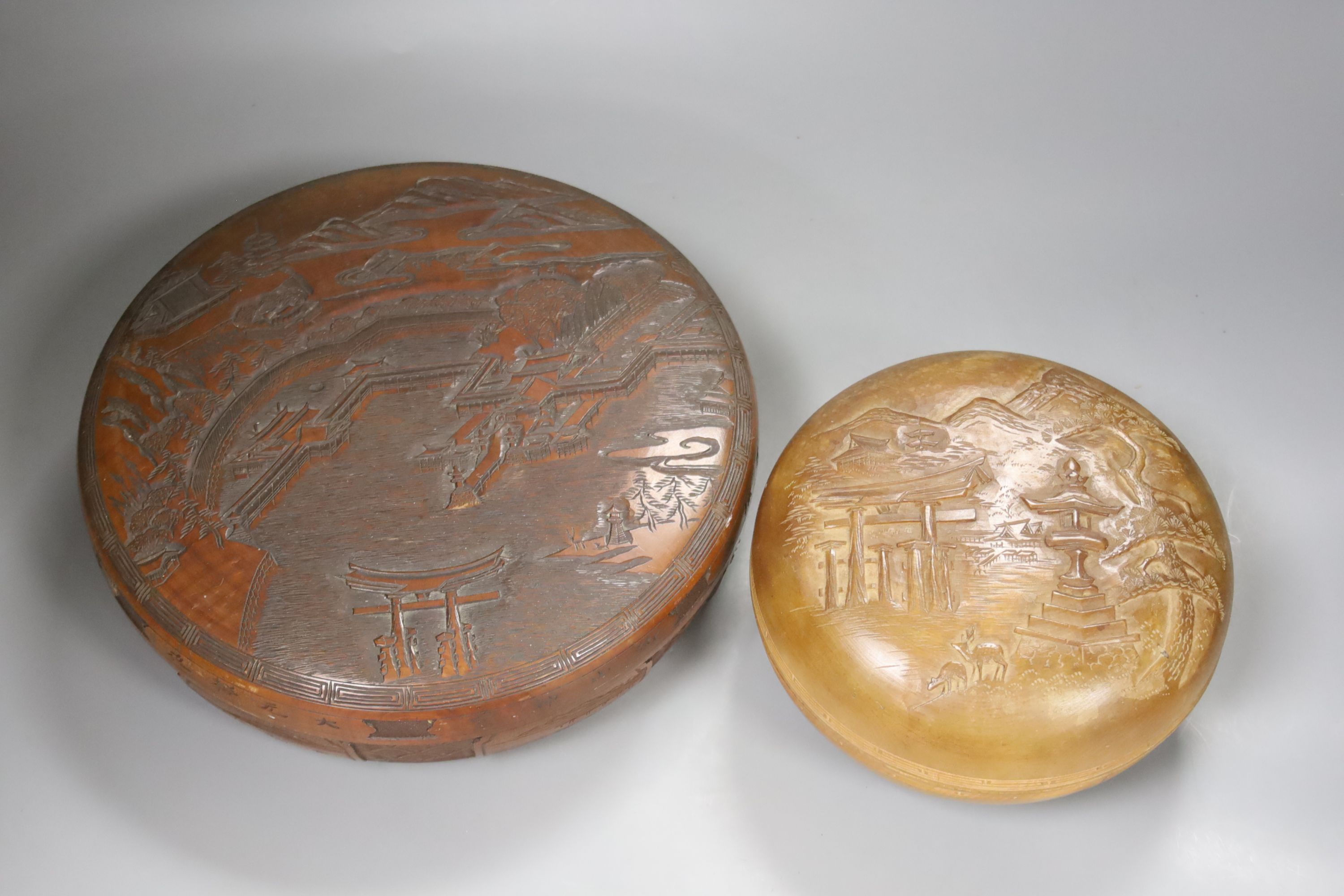 Two Japanese shallow carved wood circular lidded boxes, largest 27cm diameter